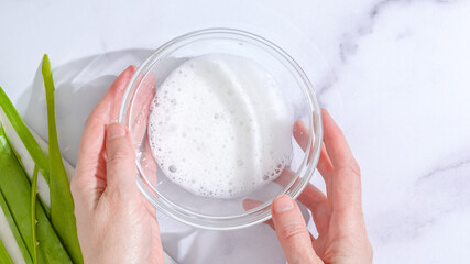 Aloe Vera homemade face and body scrub recipe. Aloe Vera gel close up in a glass bowl on marble background