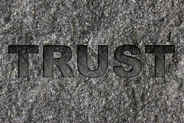 Trust etched in bold, dark gray text on black granite.
