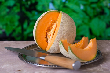 ripe melon on a silver platter in the garden shallow depth of field