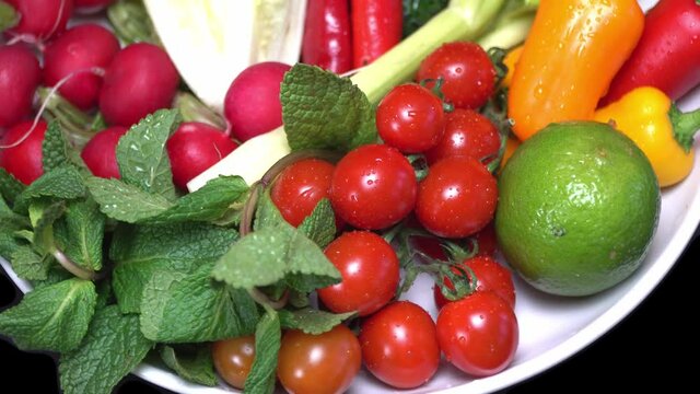 Vegetarian healthy food, vegetables: cucumbers tomatoes peppers and others on a rotating plate