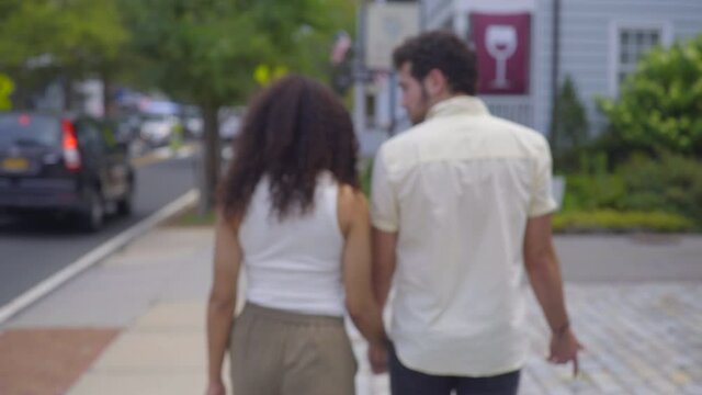 Couple Joining Hands and Walking Down the Street in a Long Island Neighborhood