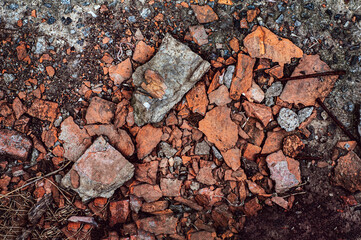 Rubbish from broken red bricks, broken building material, destruction from atmosphere, outdoors. Close-up grunge background.