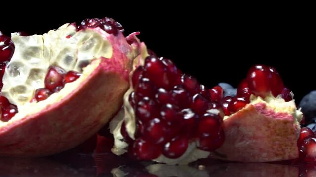 Pomegranate seeds and blueberries close up on a rotating surface