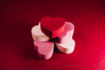 Top view of a pile of little hearts of sponges on a red background. There are some heart of red, white and pink color. San Valentine's day backgrounds concept