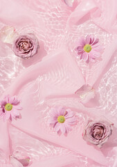 Pink rose flowers in water with silk fabric. Valentines or woman's day background design. Minimal flat lay nature.