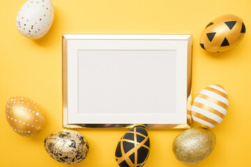 Frame with gold decorated easter eggs with copy space for text on yellow background. Minimal Happy Easter concept. Top view, flatlay