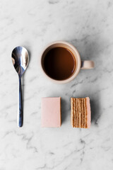 Espresso coffee and a pink cake dessert on white marble background 