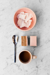 Pink cake, espresso coffee and decoration on marble background