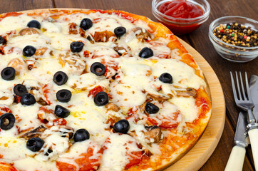 Homemade pizza with pepperoni, mushrooms, mozzarella and olives. Studio Photo