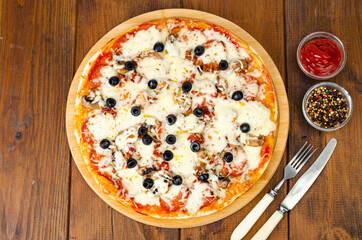 Homemade pizza with pepperoni, mushrooms, mozzarella and olives. Studio Photo