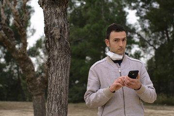 Worried young man using smartphone. Concept: internet addiction.