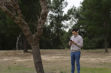 Fototapeta premium Worried young man using smartphone. Concept: internet addiction.
