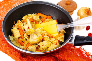 Pilaf. Rice with meat and vegetables in frying pan on white background. Studio Photo