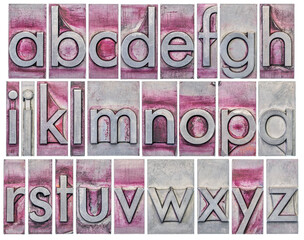 English alphabet - a collage of 26 isolated lowercase letters in grunge letterpress metal type, scratched and stained by purple ink