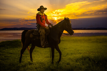 Fototapeta na wymiar cowboys horseback riding at sunset time with sunlight ray sky background