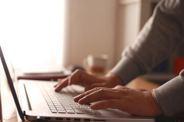 Close up of person fingers typing on laptop, business or education