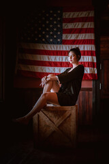 Beautiful sexy cowgirl posing vintage style with untied state 
flag background.