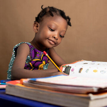 African Girl child studying alone with books on her table  