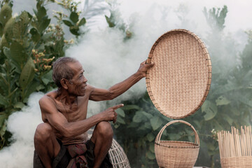 Old man is showing a tray.