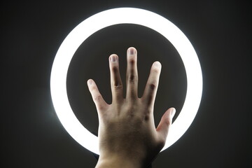 hand in the darkness with a circular light