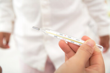 Hold the thermometer that has just taken the child's temperature