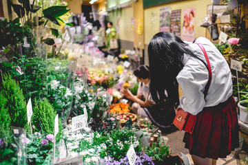 Young girls in flower store at Nishiki Market in Kyoto, Japan