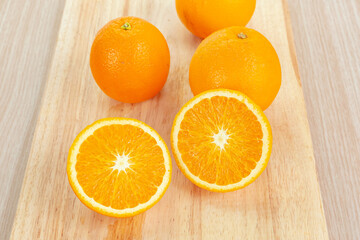 orange with slices on wooden cutting board