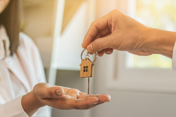 Close up hand of home,apartment agent or realtor was holding the key to the new landlord,tenant or...