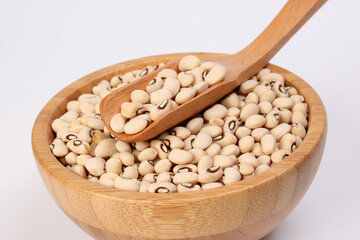 Blackeye beans in wooden bowl scoop spoon on white background