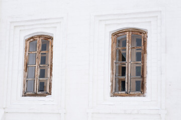Fototapeta na wymiar Two carved windows of old wooden house in historical town