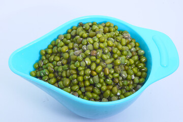 Close-up of mung beans with white isolated background.The container is blue.