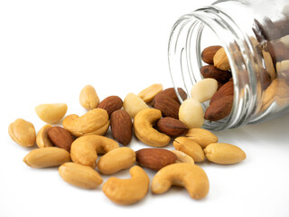 Mix nuts in glass jars isolated on white background. Almonds, macadamia, cashew, peanuts for healthy ingredients food.
