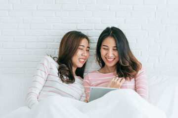 Two pretty best friends forever girlfriend talk, hug and laugh together on bed at cozy home relation fall in love. Lesbian couple homosexual happy lifestyle on bed. LGBTQ relation lifestyle concept.