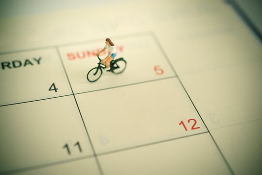 Girl riding bicycle with vintage weekend calendar