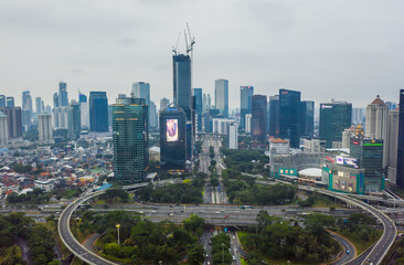 Aerial wide view of tall high rise skyscrapers and large roundabout traffic in urban city center of Jakarta, Indonesia Office and residential buildings in the city center
