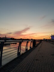 Fototapeta na wymiar Embankment under an orange evening sky