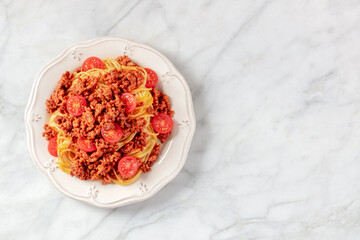 Pasta bolognese, top shot on a white marble table with a place for text