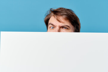 man peeking out from behind banner cropped view advertisement copy space blue background