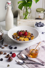 Cereal Pancakes or mini pancakes for breakfast, served with blueberries, strawberries and honey. Bright mood photography concept. White background. 