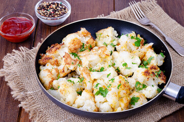 Cauliflower in batter, fried in pan. Studio Photo