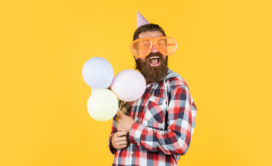 Buying gifts. happy man with beard. man in party glasses hold balloons. holiday celebration. happy...