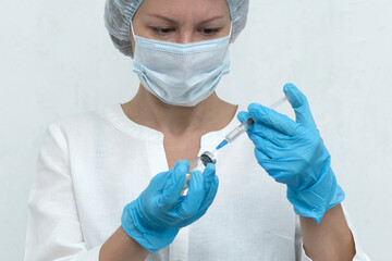 Nurse dials the injection into the syringe, vaccination