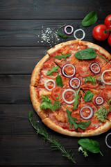 Delicious classic Italian pizza with tomatoes on a dark wooden background