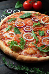 Delicious classic Italian pizza with tomatoes on a dark wooden background