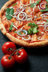 Tasty appetizing vegetarian pizza on dark stone background, top view 