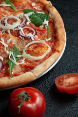 Tasty appetizing vegetarian pizza on dark stone background, top view 