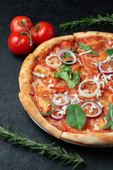 Tasty appetizing vegetarian pizza on dark stone background, top view 