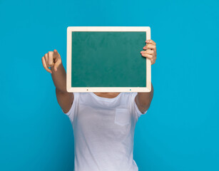 casual woman hiding behind a green board