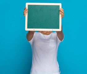 casual woman hiding behind a green board