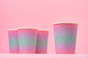 Pink disposable paper cups on pink background